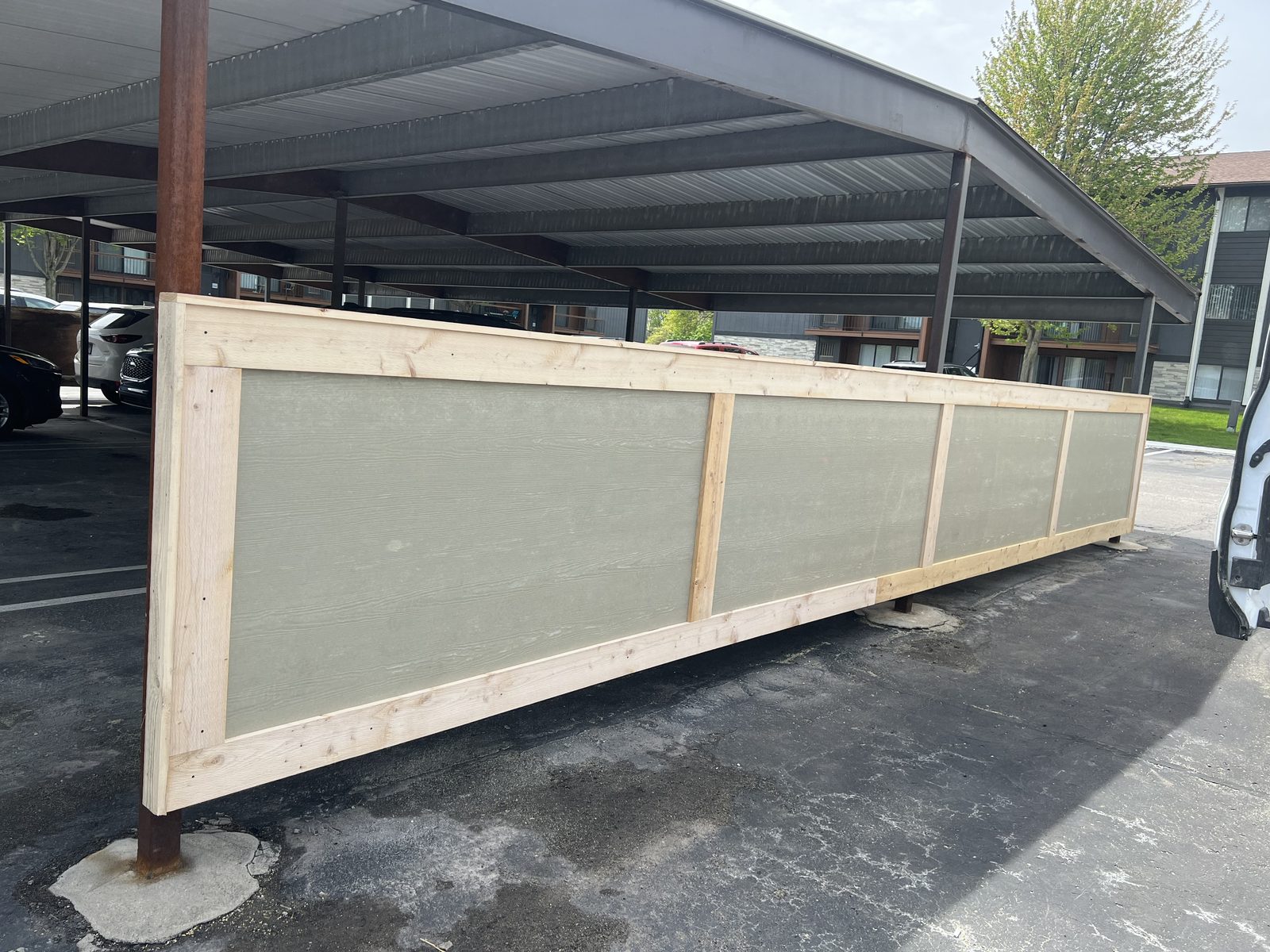 Framed panel assembly beside a carport canopy