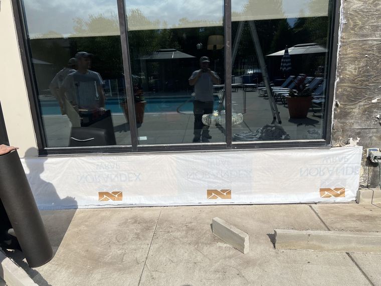 Weather barrier going on at a pool clubhouse wall