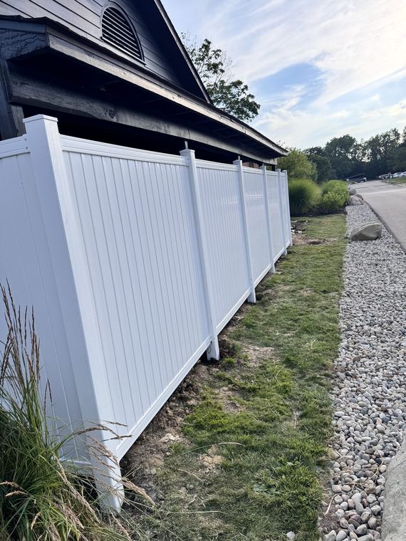 New vinyl privacy fence along a commercial property line
