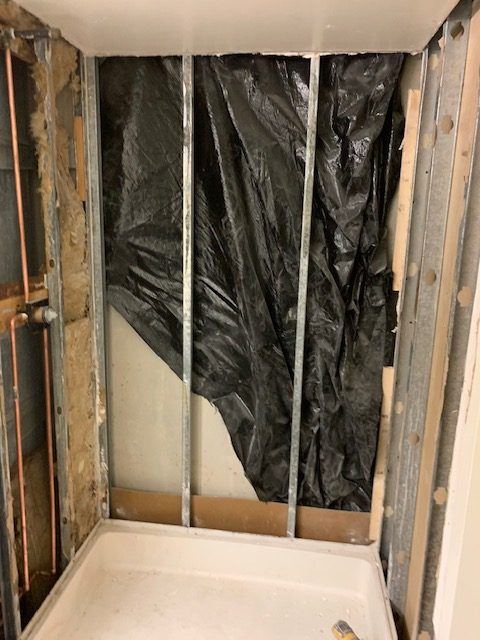 Shower stripped to the studs with vapor barrier in place